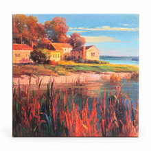 Charger l'image dans la galerie, A square canvas painting of a coastal landscape, featuring houses on a grassy shore, autumn-colored trees, a sandy beach, and a body of water under a blue sky. The painting is shown at a slight angle against a clean white background.
