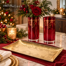 Load image into Gallery viewer, A styled holiday table scene featuring two tall red glass vases with gold floral detailing, one holding a red rose arrangement. A rectangular gold tray with ornate scrollwork sits on a red runner in front.