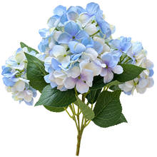 Charger l'image dans la galerie, A bouquet of artificial hydrangea flowers with light blue, white, and soft purple blooms, accented by green leaves on a solid white background.
