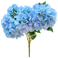 Load image into Gallery viewer, A bouquet of artificial light blue hydrangea flowers with green leaves and stems, isolated on a white background.
