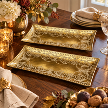Load image into Gallery viewer, Two rectangular gold serving platters with ornate white scrollwork patterns, displayed on a decorated wooden dining table.
